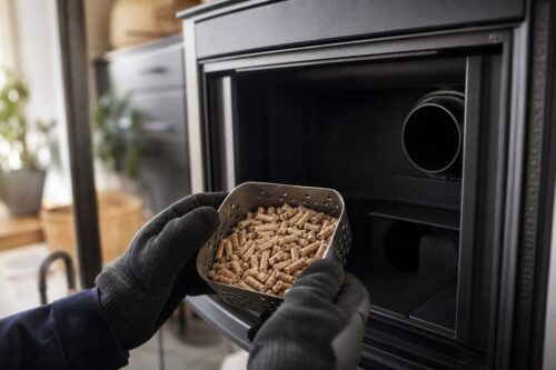 Technicien contrôlant un panier de granulés devant un insert de cheminée