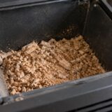 Granulés agglomérés et poussière visibles dans une trémie froide
